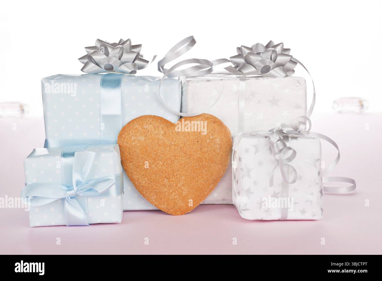 Große und kleine weihnachtsgeschenke mit herzförmigem Lebkuchen für Ihren Text. Festliches Weihnachtskonzept Stockfoto