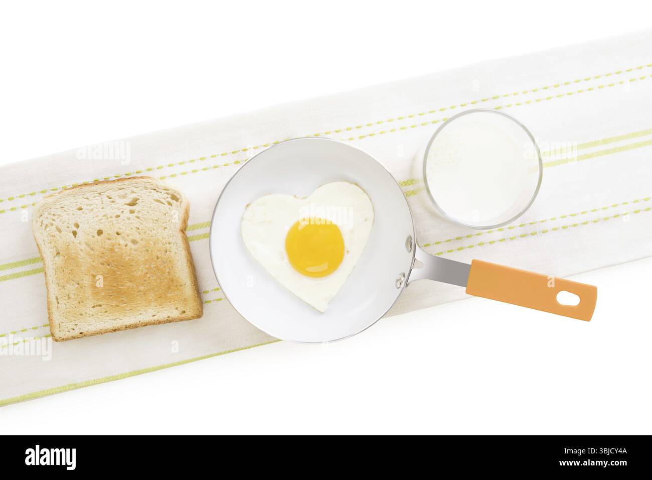 Spiegelei in Herzform in Pfanne mit Toast und Milch, Blick von oben. Ich liebe das Frühstück. Frische, moderne Bildsprache. Kulinarische Kunst Stockfoto