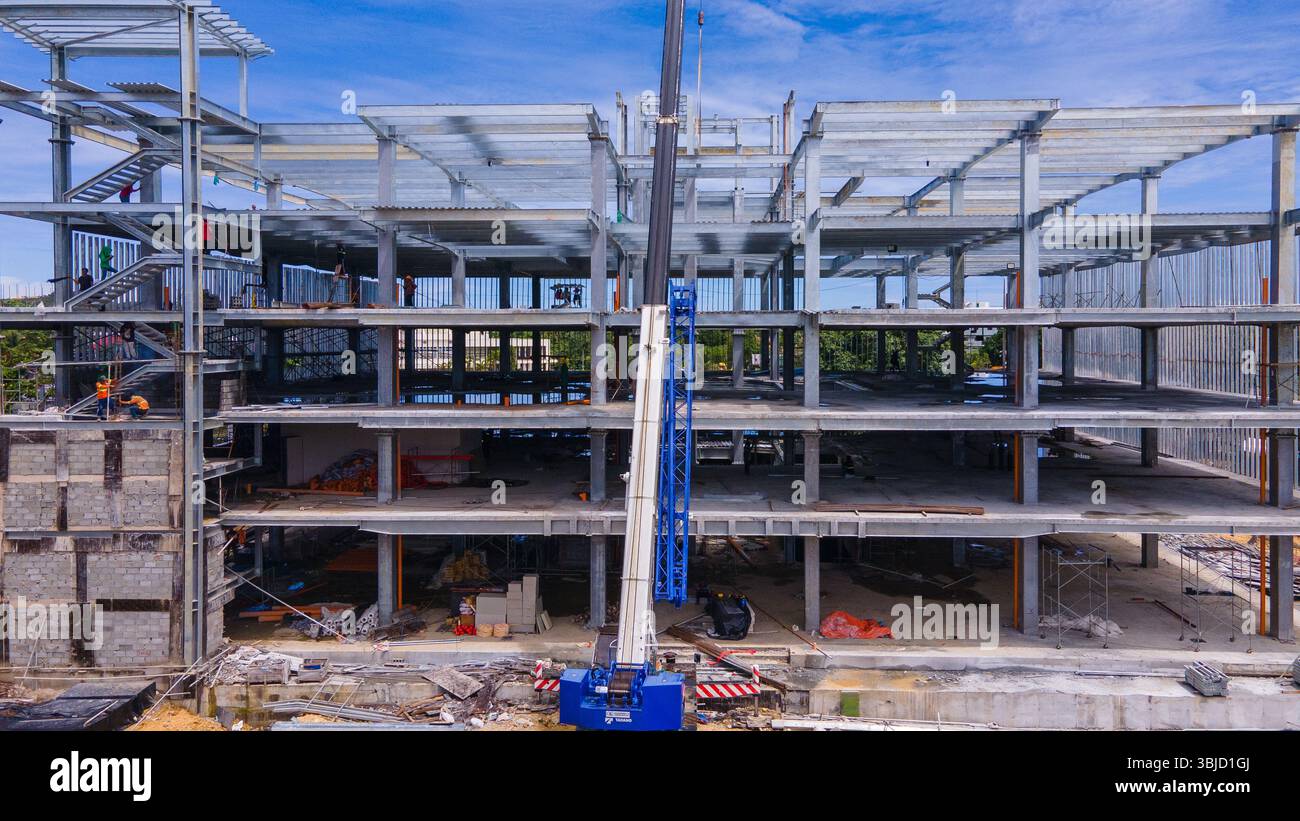 Baukran und Stahlrahmen eines im Bau befindlichen neuen Gewerbegebäudes Stockfoto