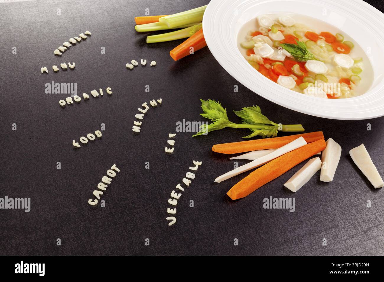 Gesunde Gemüsesuppe mit verschiedenen Gemüsesorten und Wörtern aus Alphabetnudeln. Gesunde Ernährung Gastronomie Hintergrund Stockfoto