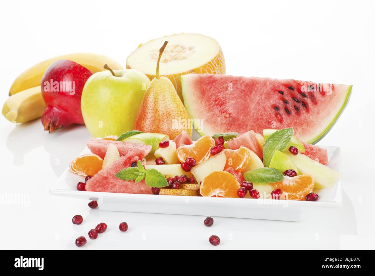 Farbenfroher Obstsalat und Obst auf weißem Teller isoliert. Frischer Sommer-Hintergrund. Wenn es darum geht, richtig zu essen und Sport zu treiben, gibt es keine, die ich anfangen werde Stockfoto