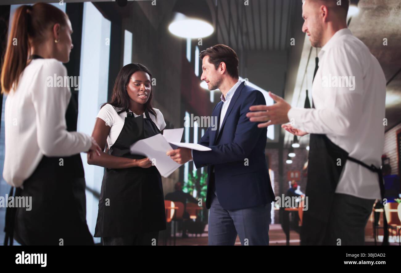 Frustrierter Restaurantchef Streitet Sich Mit Dem Diversen Team Im Coffee Shop. Stockfoto