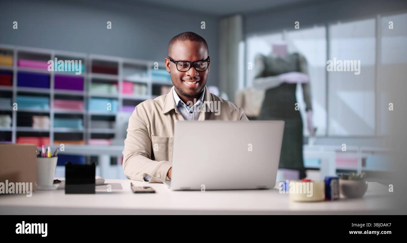 Junger Afroamerikanischer Mann, Der Laptop Benutzt, Um Mode Im Büro Zu Entwerfen. Stockfoto