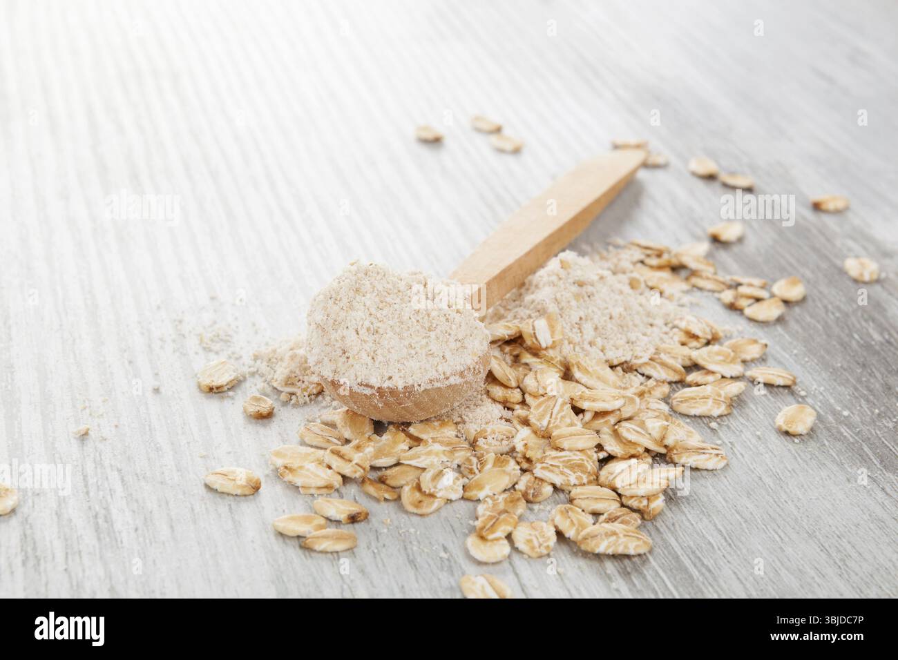 Hafermehl im Holzlöffel mit Haferflocken. Glutenfreies Konzept Stockfoto