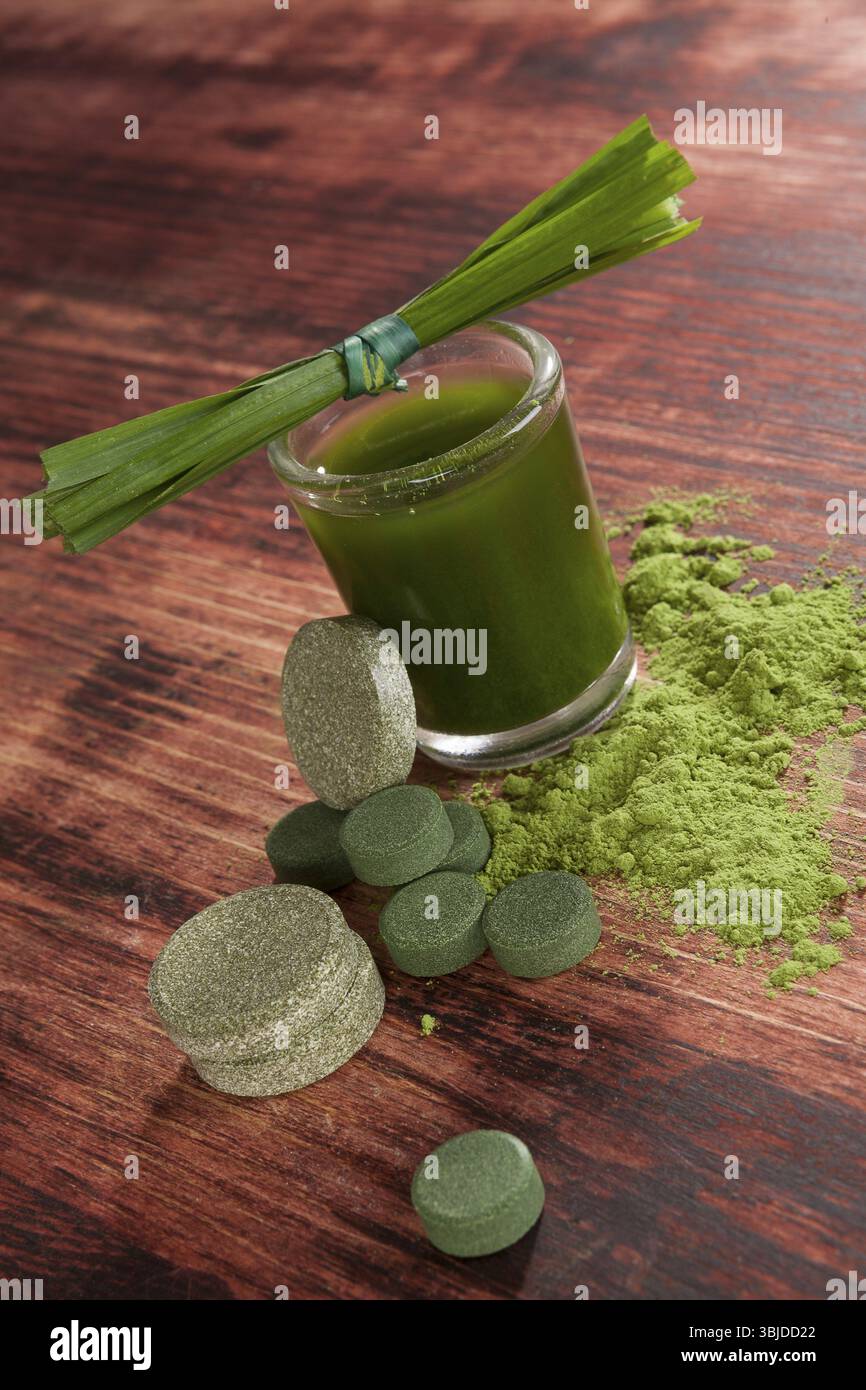 Grünes Getränk mit grünen Pillen und gemahlenem Pulver. Chlorella, Spirulina und Weizengras. Detox und alternative Medizin Stockfoto
