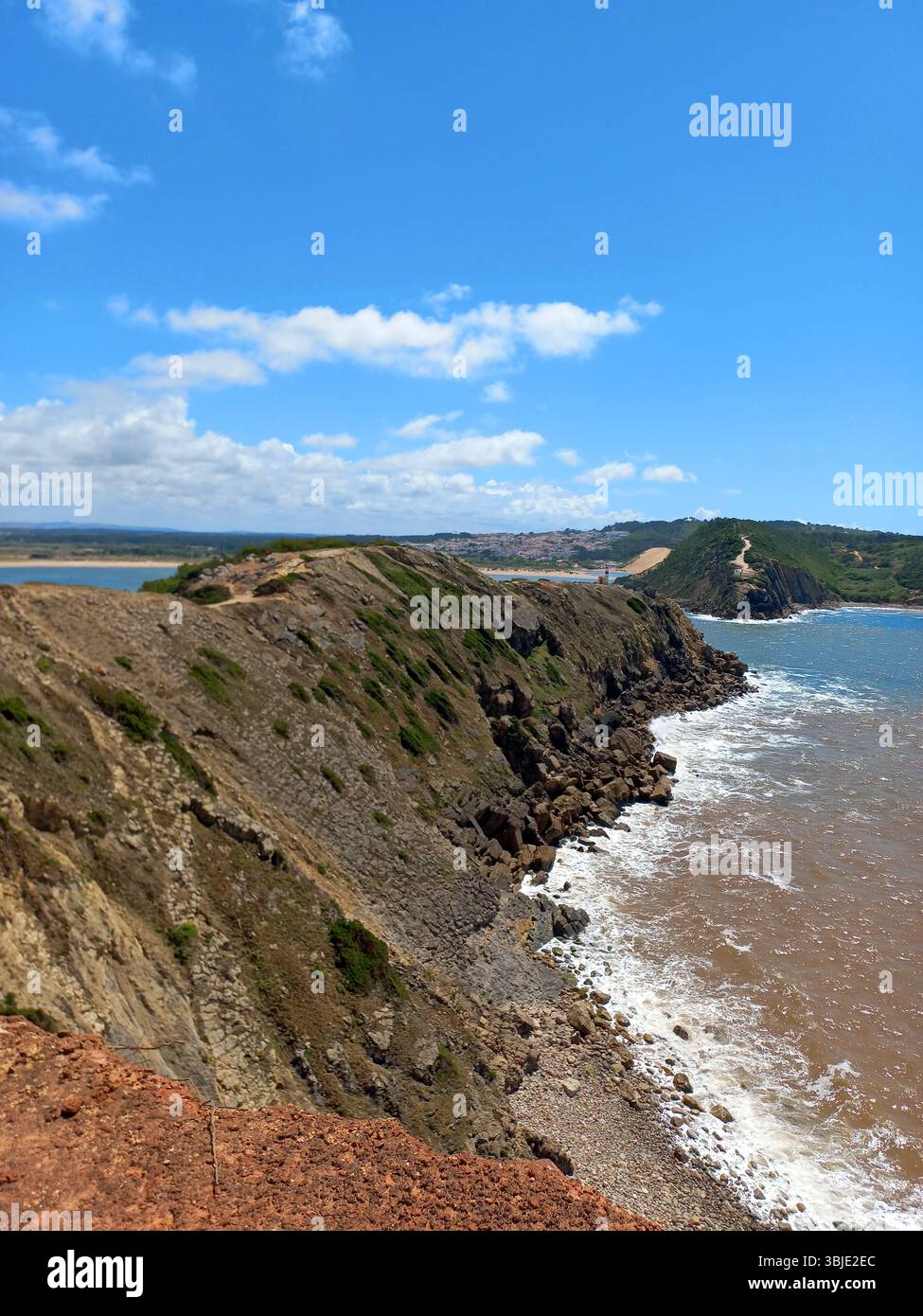 Zerklüftete Küste und felsige Klippen von São Martinho do Porto Portugal mit stürzenden Wellen und Panoramablick auf das Meer unter einem leuchtend blauen Himmel Stockfoto