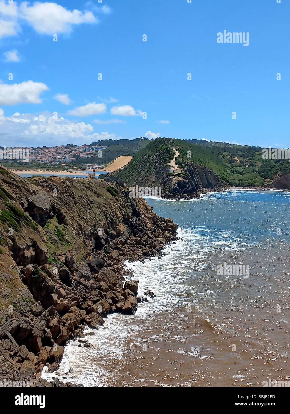 Zerklüftete Küste und felsige Klippen von São Martinho do Porto Portugal mit stürzenden Wellen und Panoramablick auf das Meer unter einem leuchtend blauen Himmel Stockfoto
