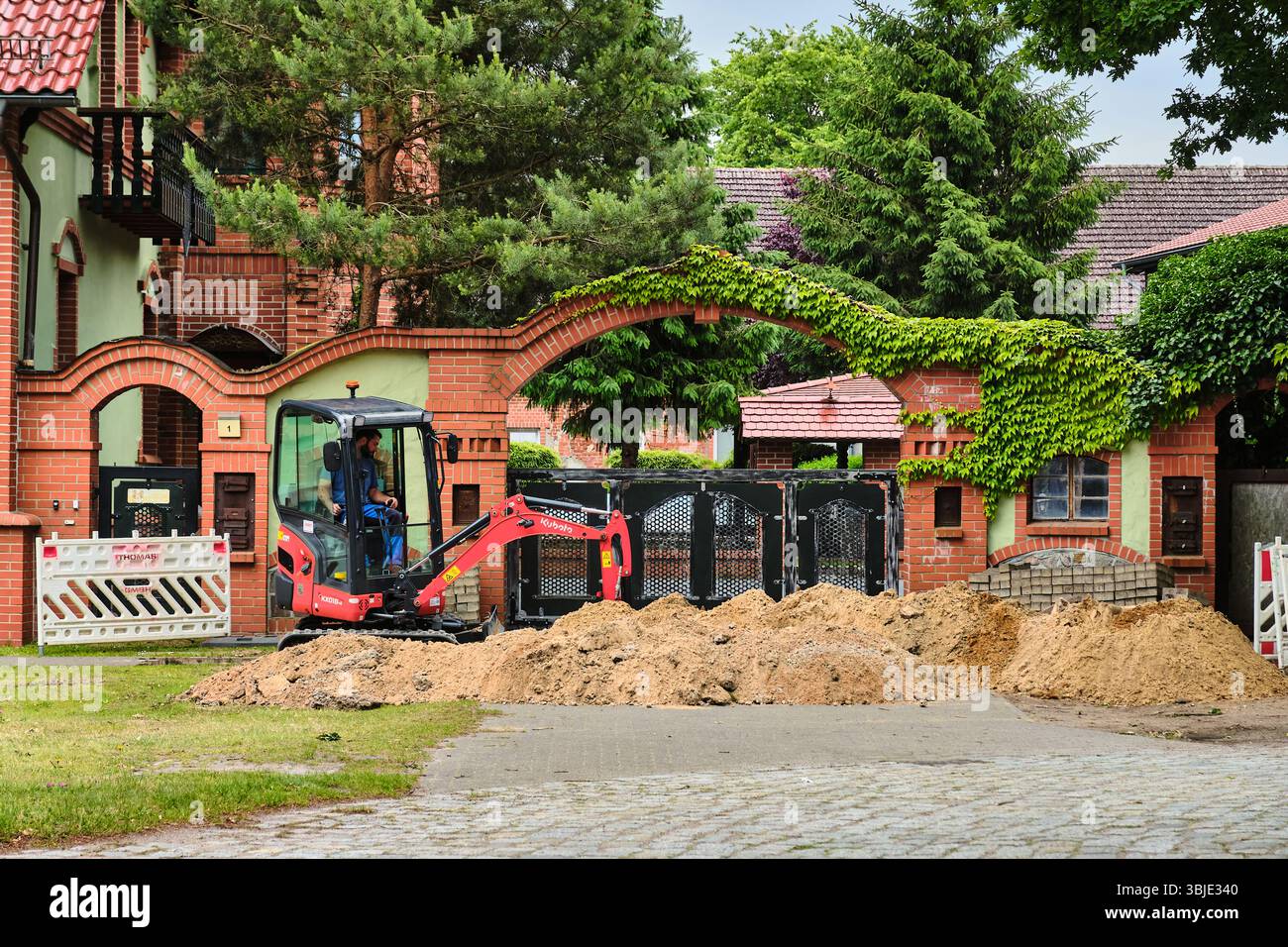 10. Juni 2025 – Teschendorf, Deutschland: Minibagger zur Vorbereitung des Grabens für die Glasfaserkabelinstallation, Teil der ländlichen deutschen Infrastrukturerweiterung Stockfoto