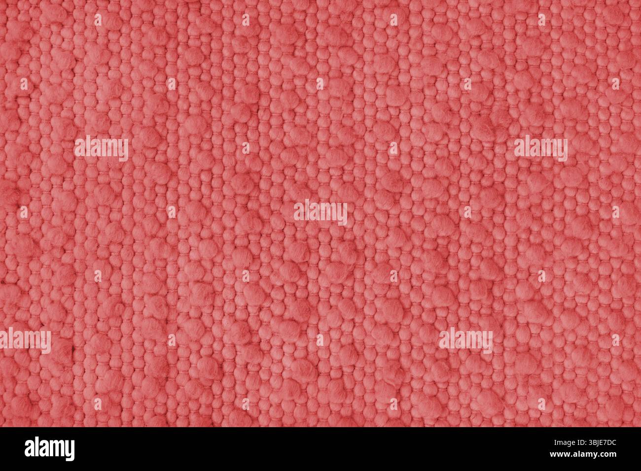 Textur von rotem Teppichgewebe mit grober Textur. Oberfläche, Struktur von Polstern oder Teppichmaterial, Stoffhintergrund Nahaufnahme, Makro. Stockfoto