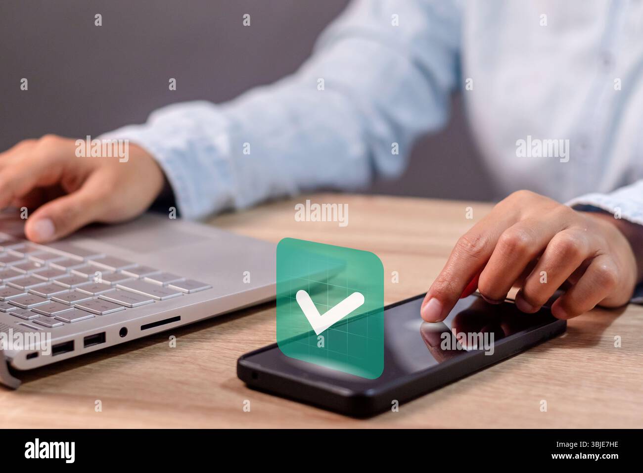 Eine Geschäftsfrau, die ein Smartphone mit grünem Häkchen auf dem Bildschirm nutzt. Validiertes, bestätigtes, abgeschlossenes, genehmigtes und verifiziertes Konzept. Stockfoto