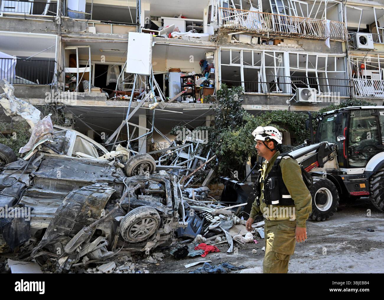 Ein israelischer Rettungsdienst läuft an zerstörten Autos und Wohnungen an der Stelle vorbei, an der eine iranische ballistische Rakete am Sonntag, den 15. Juni 2025, in ein Wohngebäude in bat Yam einschlug. Mindestens sieben Menschen wurden getötet und Hunderte verletzt, während Rettungskräfte unter den Trümmern nach Vermissten suchen. Foto: Debbie Hill/UPI Stockfoto