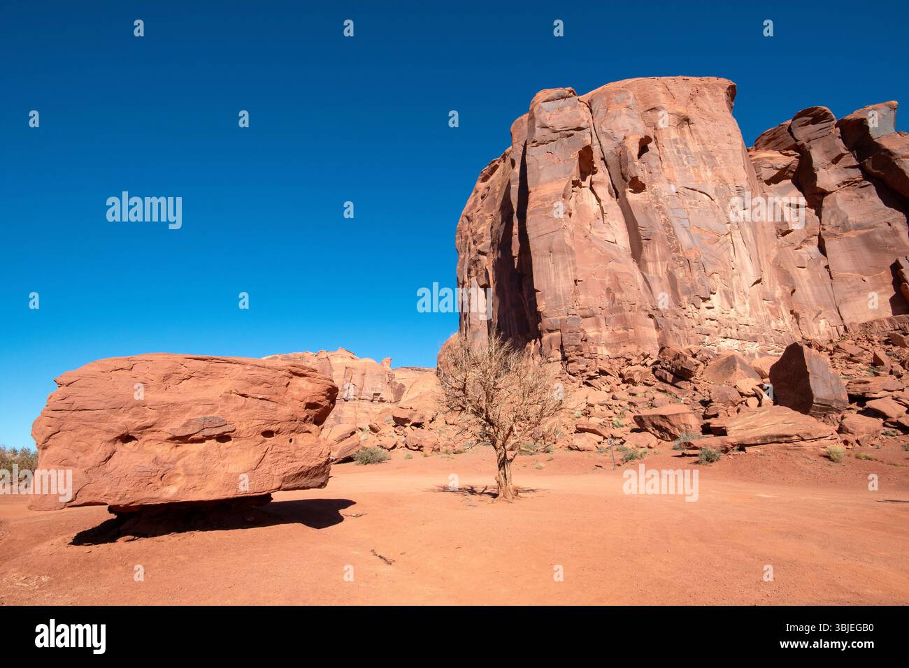 Große Felsformation und einsames quadratisches Gestein im Monument Valley Navajo Tribal Park, Arizona, USA Stockfoto