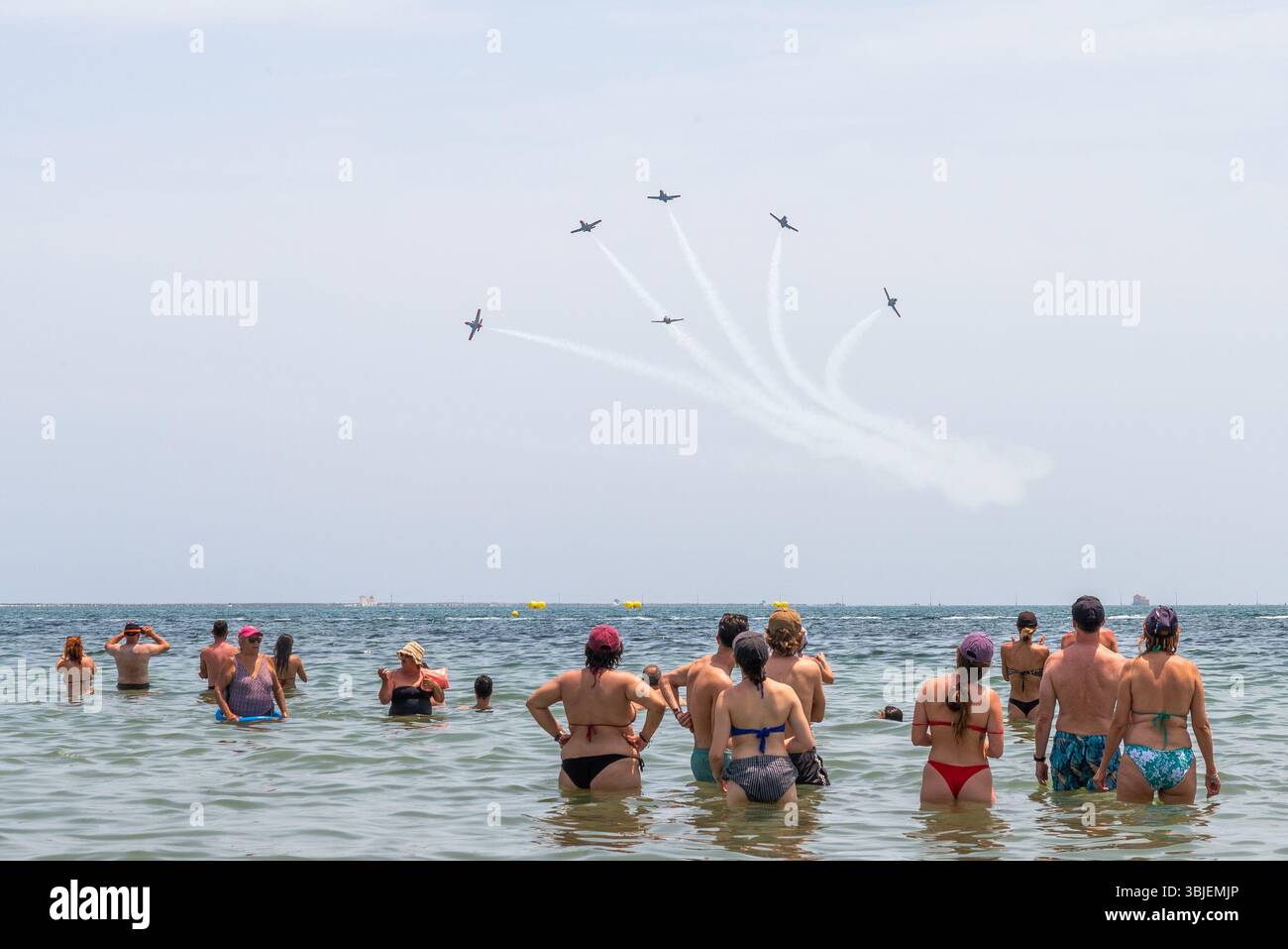 Santiago de La Ribera, San Javier, Spanien. Juni 2025. Das Kunstflugteam der spanischen Luft- und Raumfahrtstreitkräfte namens Patrulla Águila (Eagle Patrol) wurde am 4. Juli 1985 gegründet und feiert sein 40-jähriges Bestehen und das Ende seiner Zeit, als sie die Casa C-101 Aviojets auf Pilatus PC-21 Turboprop-Flugzeuge umsteigen. Die Jets, die über die Strände des Mar Menor zeigen, mit Menschen, die im Meer beobachten Stockfoto