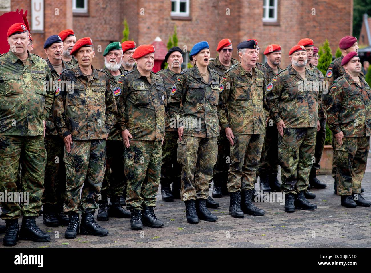 Vechta, Deutschland. Juni 2025. Zahlreiche Reservisten stehen vor dem Arsenal und singen die deutsche Nationalhymne im Rahmen des Nationalveteranentages für einen Reservistennamentakt mit Vereidigung in der Zitadelle von Vechta. An diesem Tag werden alljährlich der Dienst, das Engagement und die Leistungen von Soldaten der Bundeswehr geehrt, die im Einsatz sind oder waren. Quelle: Hauke-Christian Dittrich/dpa/Alamy Live News Stockfoto