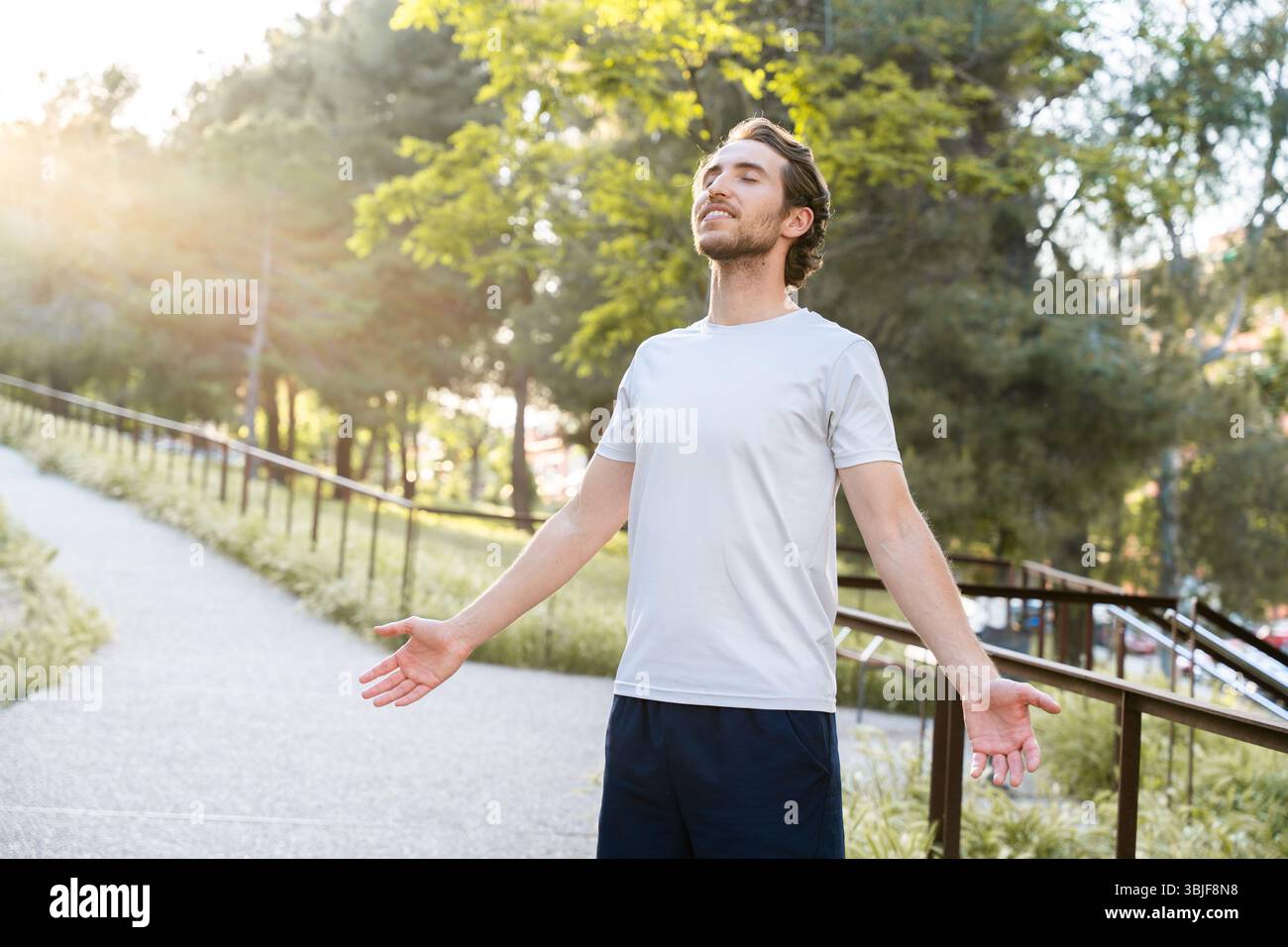 Mann im Stadtpark zeigt geistiges Wohlbefinden nach körperlichem Training Stockfoto