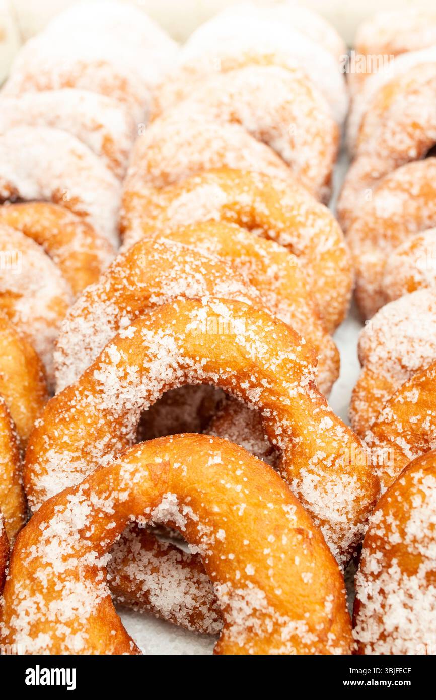 Donuts Reihen gepudert mit grobem Kristallzucker, weicher Fokus aus der Nähe Stockfoto