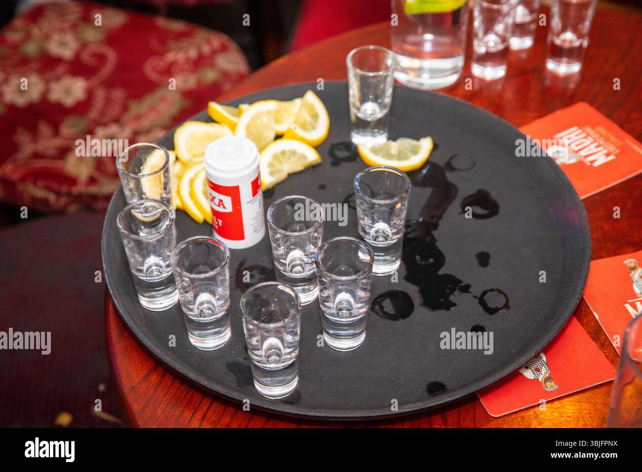 Leere Shot-Gläser auf einem Tablett mit Zitronenscheiben und Salz zum Trinken von Tequila Stockfoto
