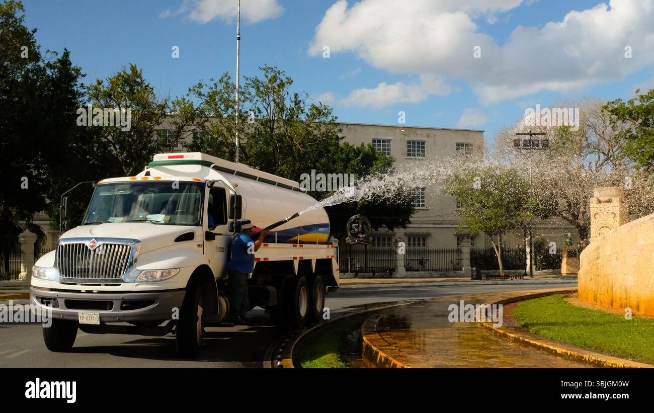 Stadtarbeiter, die Gras bewässern, neben dem Vaterlanddenkmal auf der berühmten Avenue Paseo de Montejo, Merida, Mexiko Stockfoto
