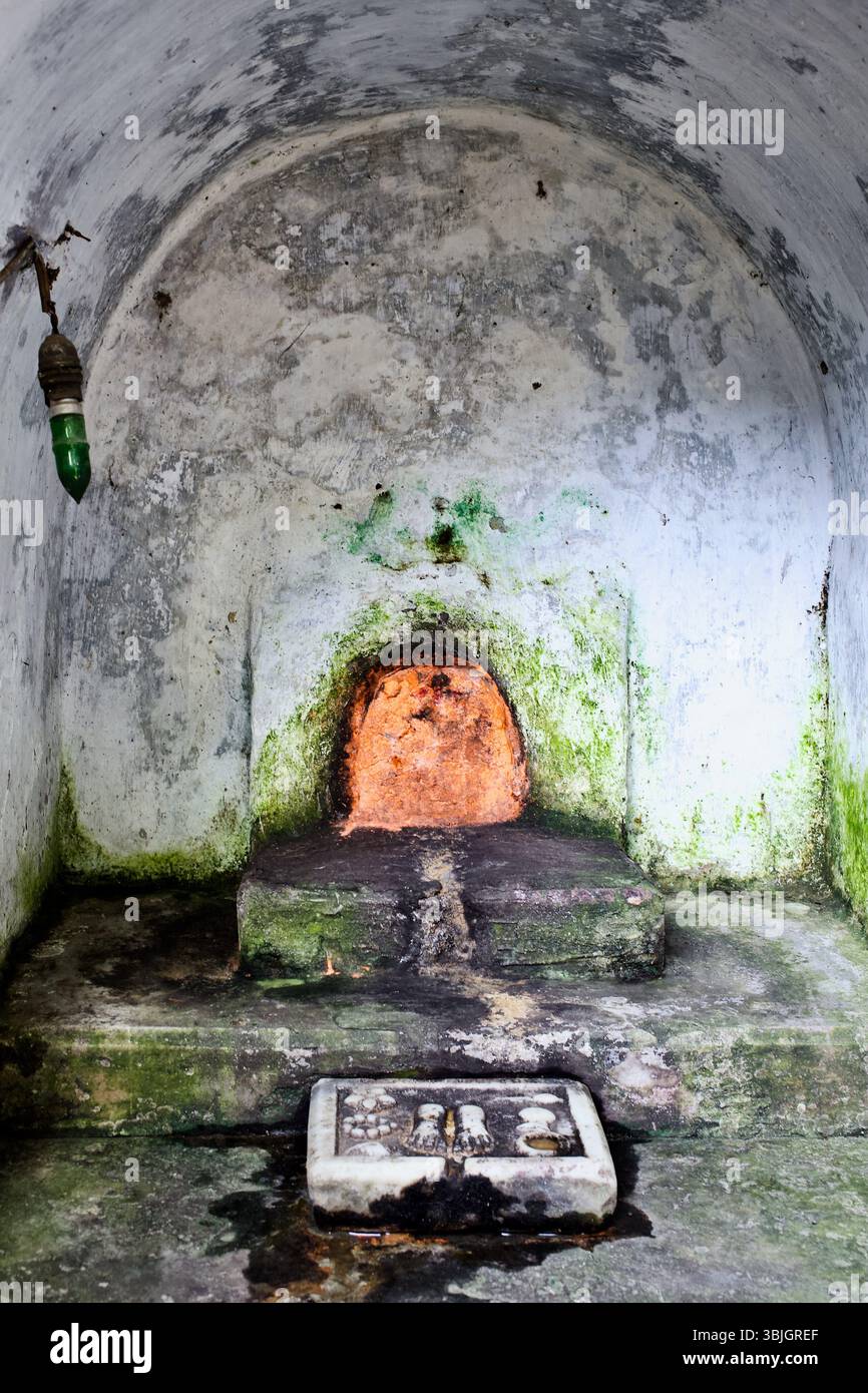 In Stein gemeißelte paduka in einer verwitterten Schrein-Nische in Rajshahi spiegelt lokale hinduistische Andachtsmethoden und anhaltende Formen der Volksverehrung wider. Stockfoto