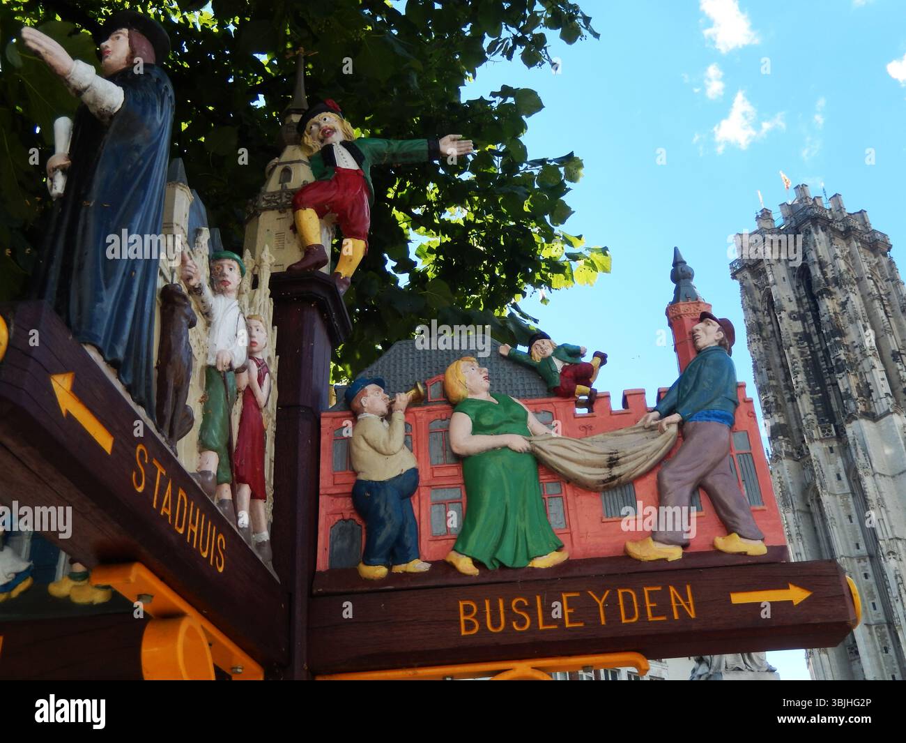 Farbenfrohe Skulptur mit historischen Figuren und einem Kirchturm. Mechelen, Belgien Stockfoto