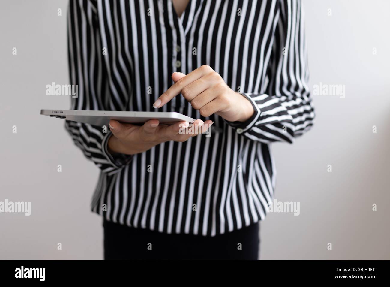 Nahaufnahme von weiblichen Händen, die ein digitales Tablet berühren. Nahaufnahme der Hände mit einem digitalen Tablet. Stockfoto