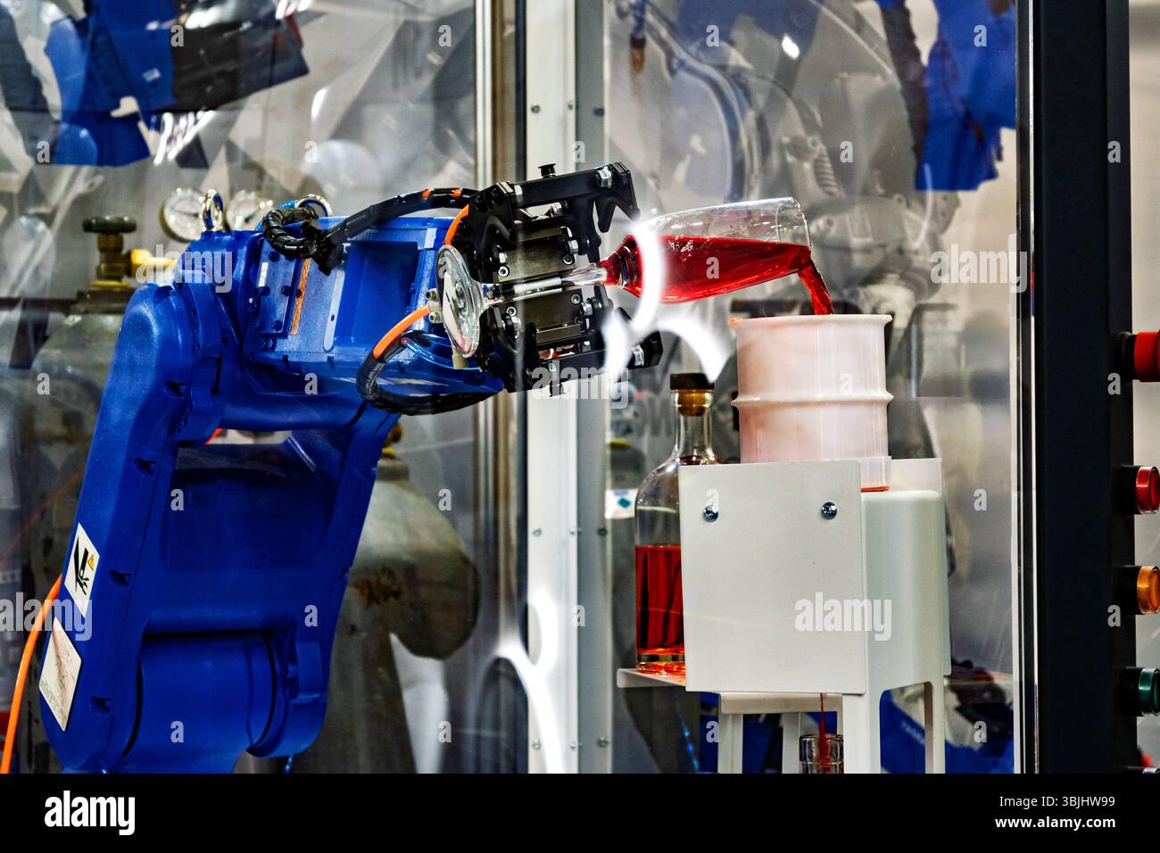 Der automatisierte Roboterarm gießt Flüssigkeit in einen Behälter, eine Darstellung der Fabrik der Zukunft. Stockfoto