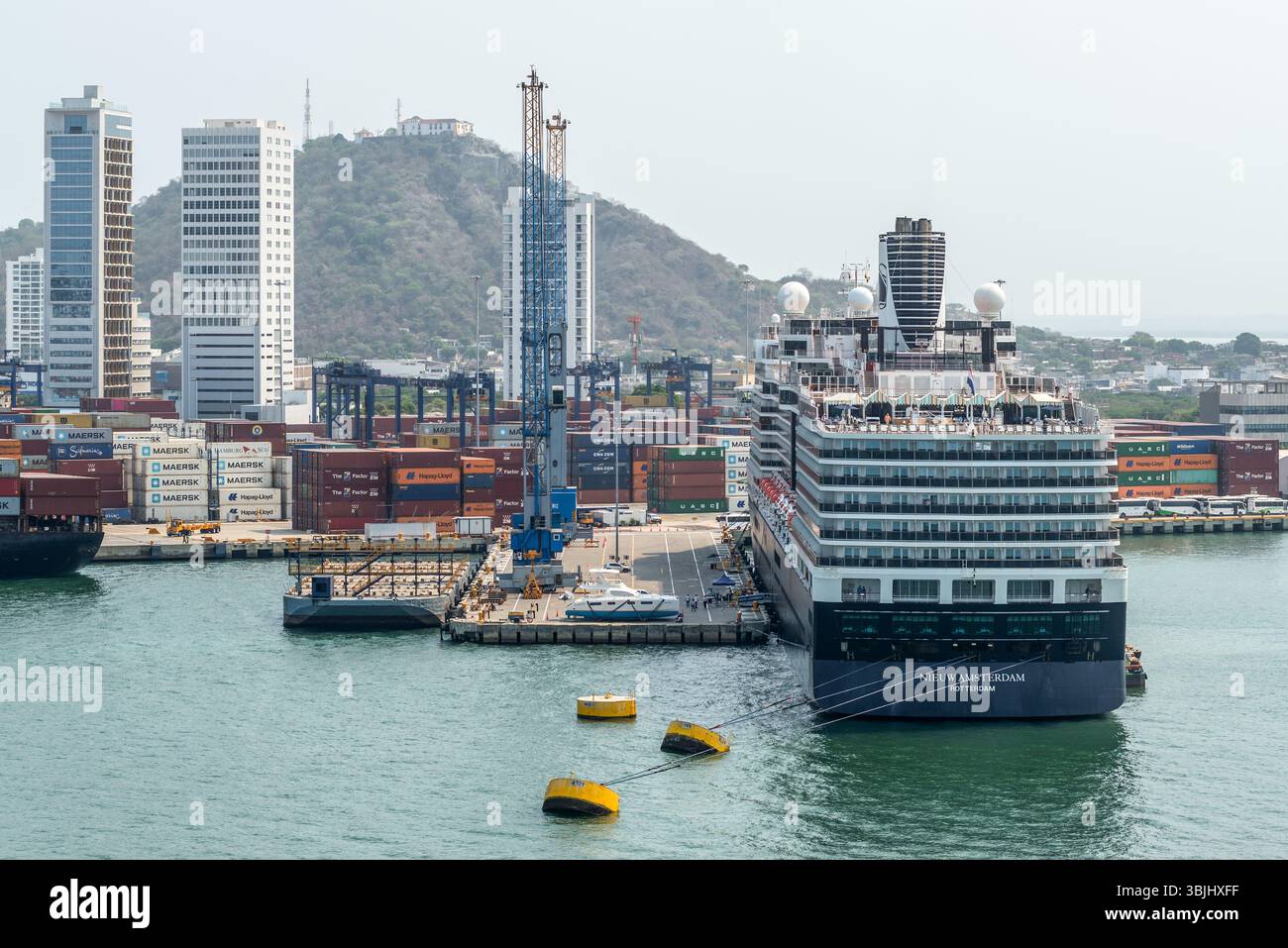 Cartagena, Kolumbien - 12. April 2024: Die Hafenszene mit einem Kreuzfahrtschiff Nieuw Amsterdam, Hafenkränen und Schiffscontainern steht gegen die BA Stockfoto