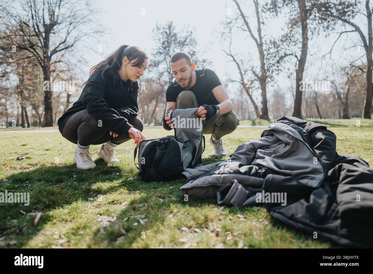 Zwei Teenager genießen einen sonnigen Tag im Freien und organisieren ihre Ausrüstung in einem Park. Stockfoto