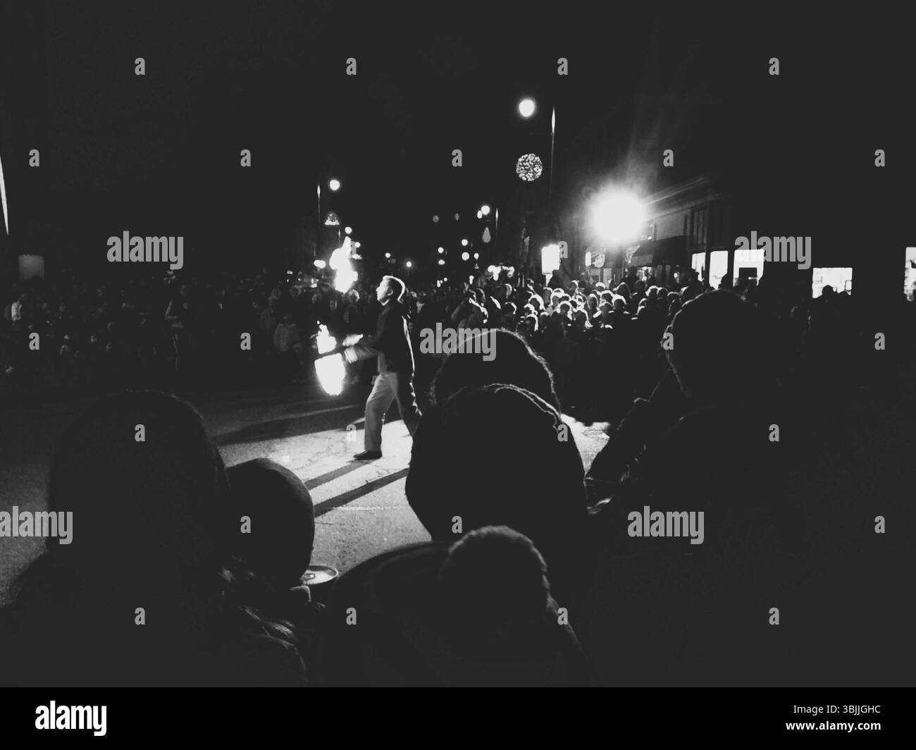 Ein Mann jongliert Feuer, um die Menge während des ersten Freitags Art Walk in Portland, Maine, zu unterhalten. Stockfoto