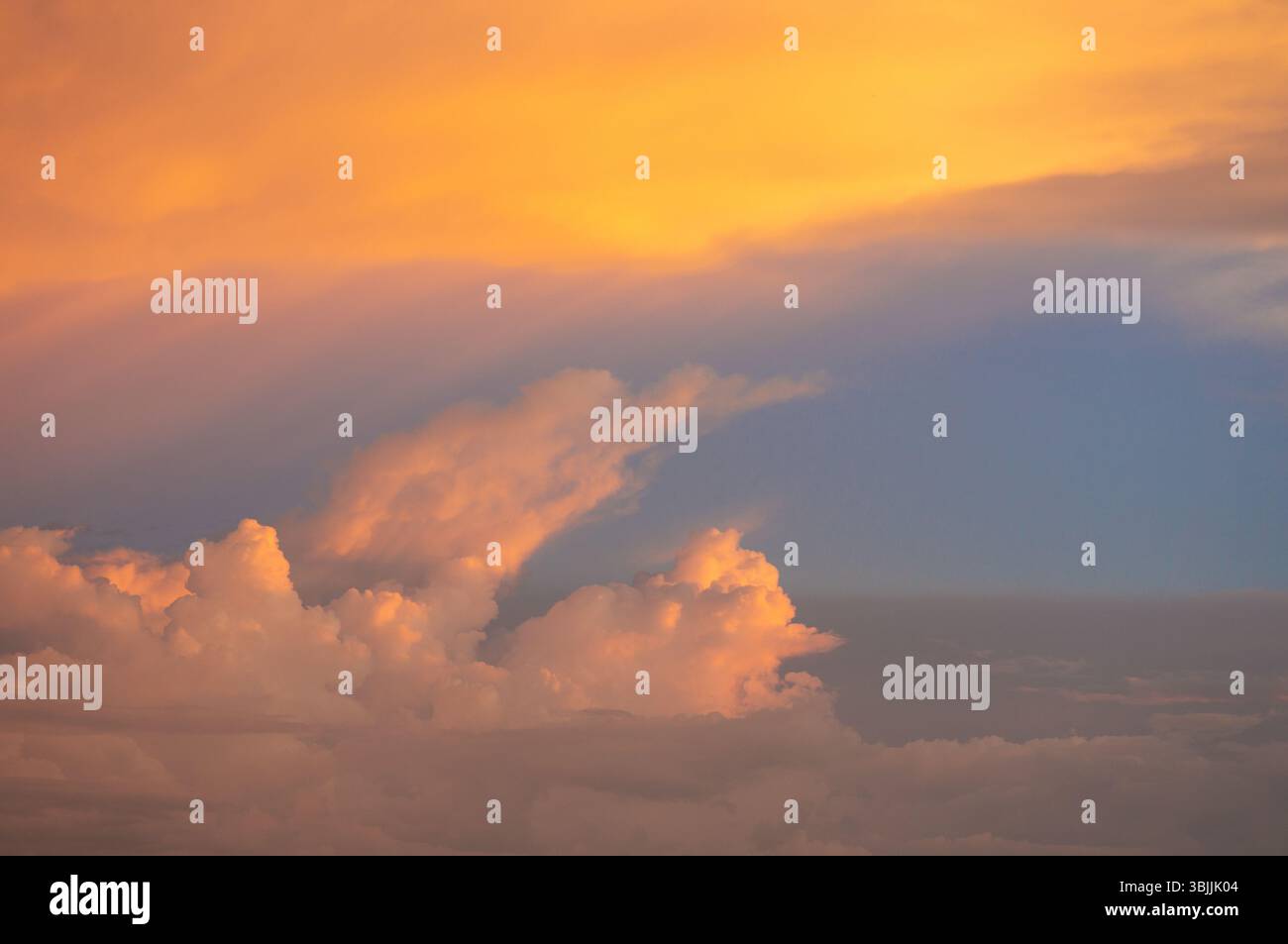 Sonnenuntergangswolken mit goldenen und violetten Tönen über dem Abendhimmel Stockfoto