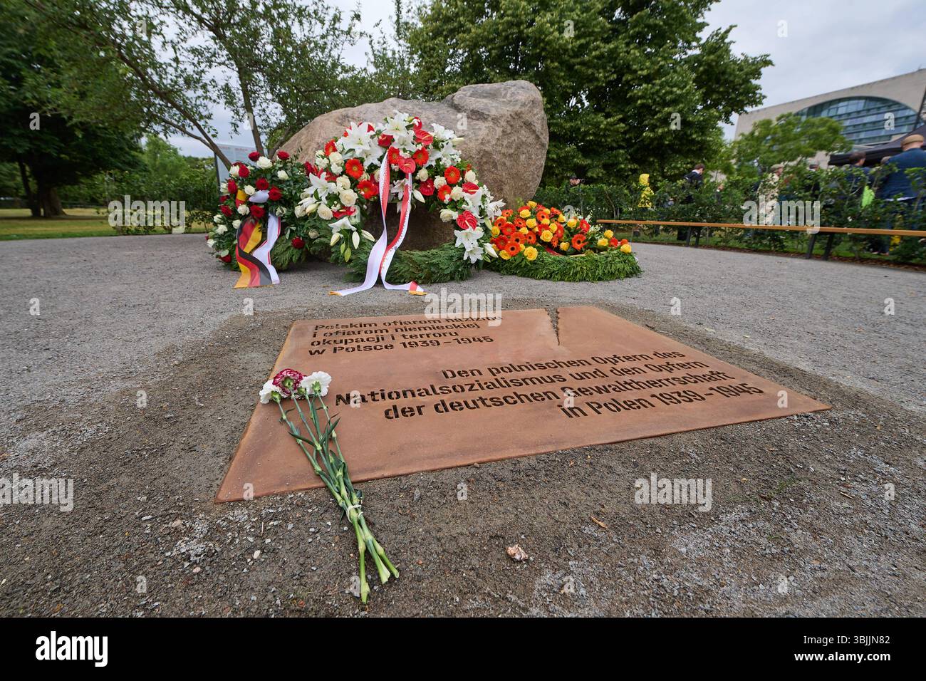 Im Berliner Regierungsviertel ist am Montag 16.06.2025 ein temporaerer Gedenkort für die Opfer der deutschen Besatzung Polens im Zweiten Weltkrieg eingeweiht worden. Das aus einem 30 Tonnen schweren Findling und einem Wildapfelbaum bestehende Gedenkzeichen gegenueber der Reichstagswiese befindet sich auf dem Gelaende der ehemaligen Kroll-Oper, in der Adolf Hitler am 1. September 1939 den Ueberfall Deutschlands auf Polen verkuendet hatte. Gewidmet ist das Denkmal in deutscher, polnischer und englischer Sprache den polnischen Opfern des Nationalsozialismus und den Opfern der deutschen Gewalther Stockfoto