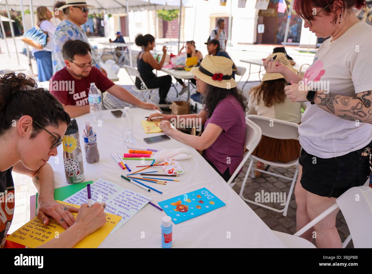 Los Angeles, CA, USA. Juni 2025. Freiwillige machen Vatertagskarten für die Summer of Resistance Coalition für eingewanderte Häftlinge im Fed Building in LA am 3. Tag der 30-tägigen Aktion unter der Leitung von CLUE: Clergy and Laity United for Economic Justice. Sie befinden sich unter einem Zelt in der historischen Placita Olvera Downtown Los Angeles. Mit SEIU 721, Coalition for Humane Immigrant Rights Central American Resource Center (Credit Image: © Amy Katz/ZUMA Press Wire) NUR REDAKTIONELLE VERWENDUNG! Nicht für kommerzielle ZWECKE! Stockfoto