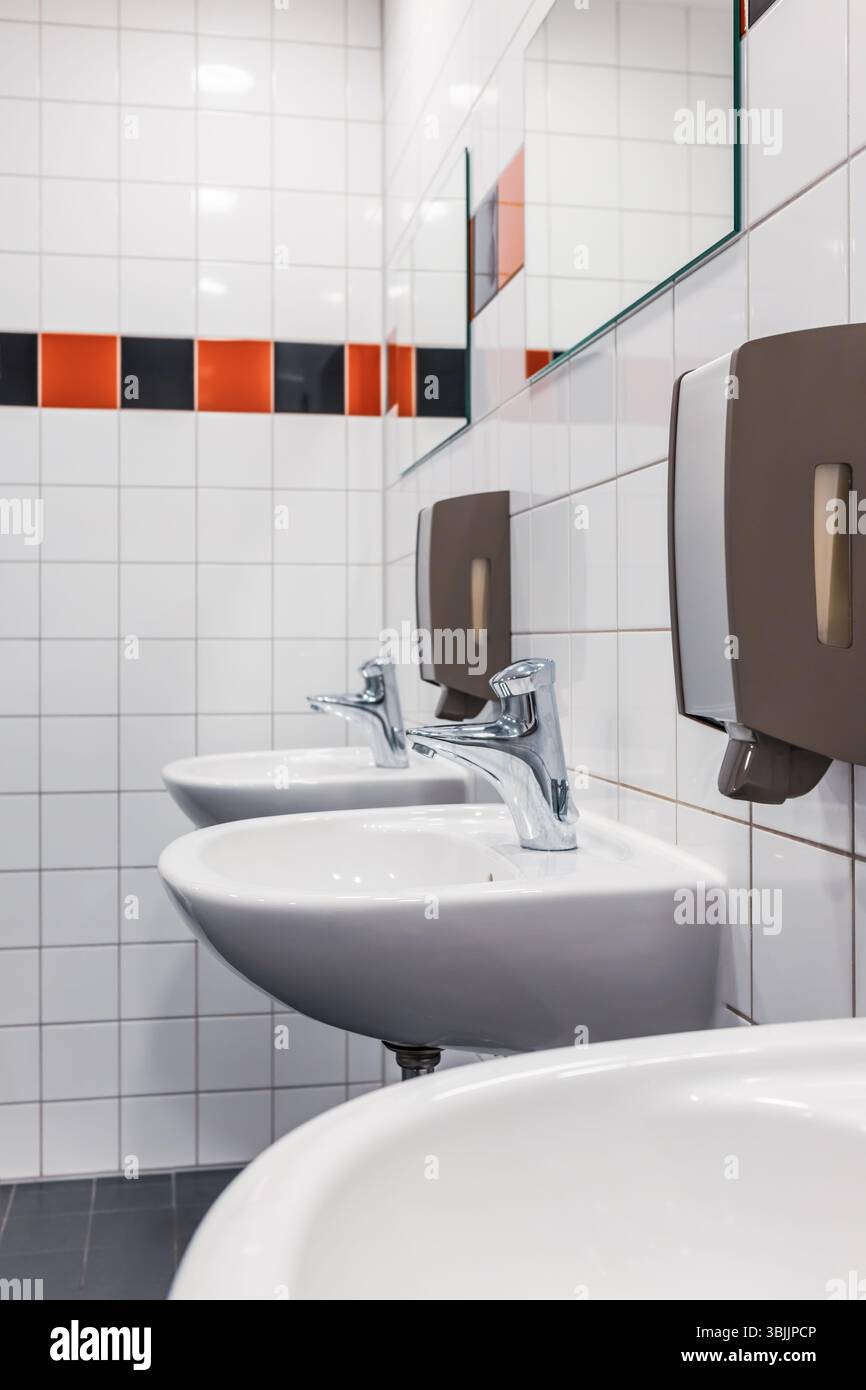 Öffentliches Bad in minimalistischem Stil. Badezimmer mit Waschbecken und Seifenspender Stockfoto