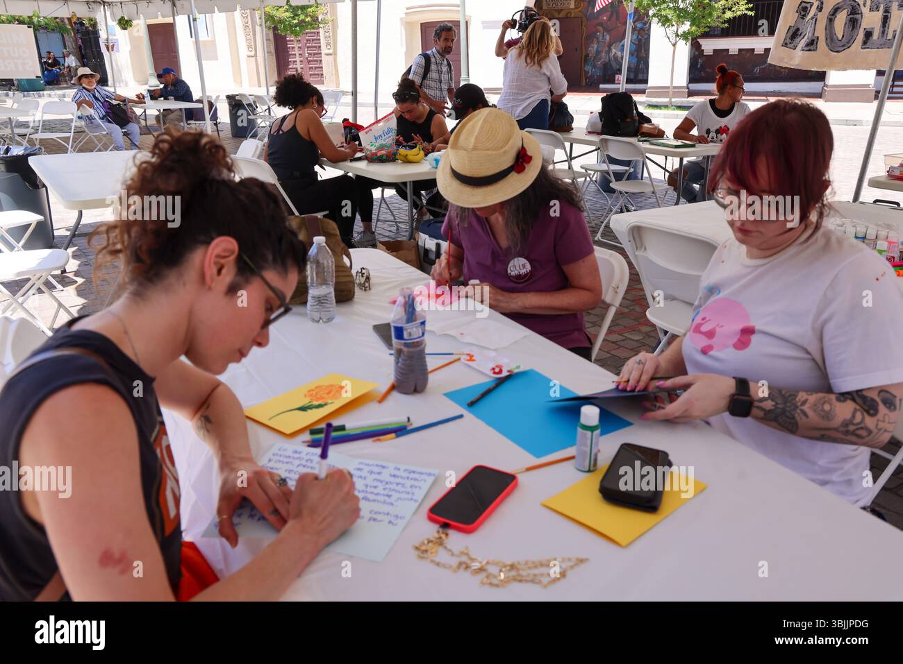 Los Angeles, CA, USA. Juni 2025. Freiwillige machen Vatertagskarten für die Summer of Resistance Coalition für eingewanderte Häftlinge im Fed Building in LA am 3. Tag der 30-tägigen Aktion unter der Leitung von CLUE: Clergy and Laity United for Economic Justice. Sie befinden sich unter einem Zelt in der historischen Placita Olvera Downtown Los Angeles. Mit SEIU 721, Coalition for Humane Immigrant Rights Central American Resource Center (Credit Image: © Amy Katz/ZUMA Press Wire) NUR REDAKTIONELLE VERWENDUNG! Nicht für kommerzielle ZWECKE! Stockfoto