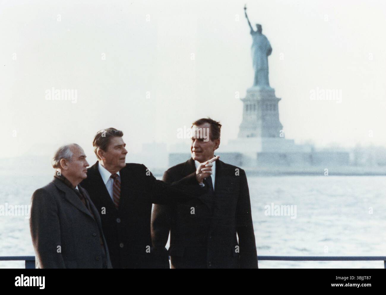 Präsident Reagan und Vizepräsident Bush treffen sich mit Generalsekretär Gorbatschow auf der Insel des Gouverneurs, Freiheitsstatue im Hintergrund, 1988 Stockfoto
