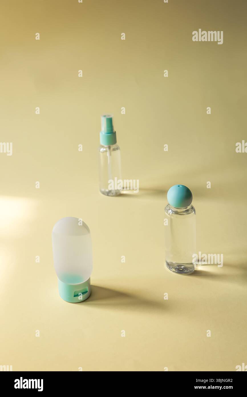 Flaches Lagen von drei nachfüllbaren Kosmetikbehältern mit weichen Schatten auf pastellfarbenem Hintergrund. Sauberes, elegantes Design, perfekt für Hautpflege- oder Hygienekonzepte Stockfoto