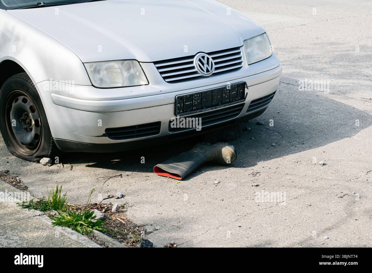 Akranes, Island – 15. Juni 2025: Ein silbernes Auto mit sichtbarem Schaden parkt in einer städtischen Umgebung mit einem einzigen Kofferraum. Stockfoto