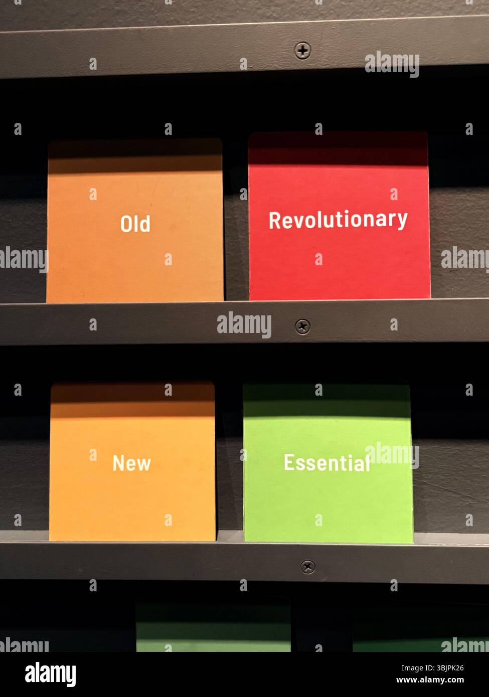 Kleine Karten mit der Aufschrift „alt“, „revolutionär“, „neu“, „essentiell“. - Smartphone-aufgenommenes Stockfoto