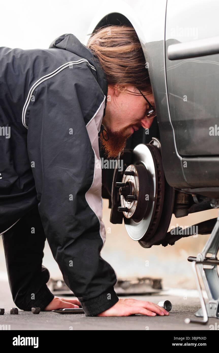 Junger Mann mitten in einer Autowerkstatt Stockfoto