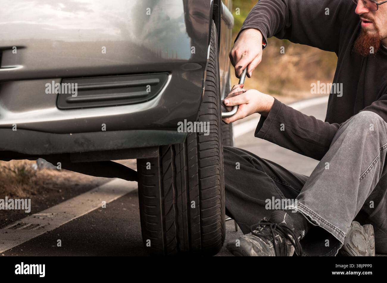 Junger Mann repariert Auto im Freien Stockfoto