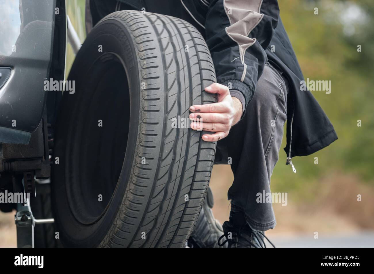 Junger Mann Reparatur Auto im Freien sitzen Stockfoto