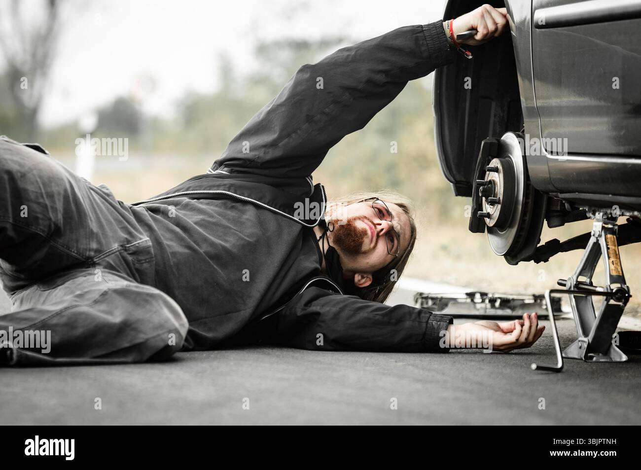 Hübscher junger Mann, der Auto repariert Stockfoto