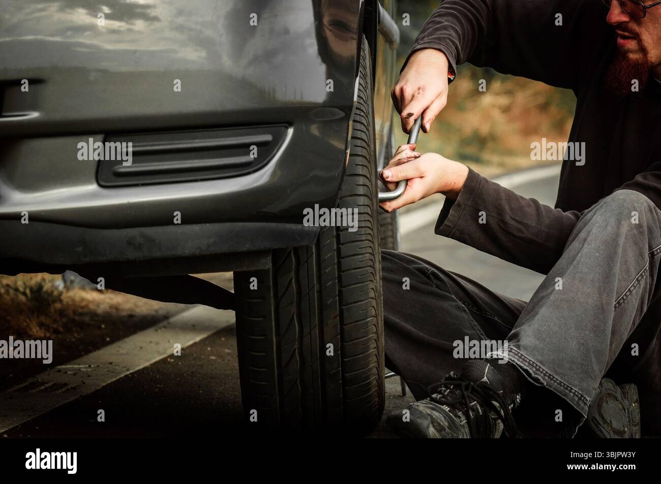 Junger Mann repariert Auto im Freien Stockfoto