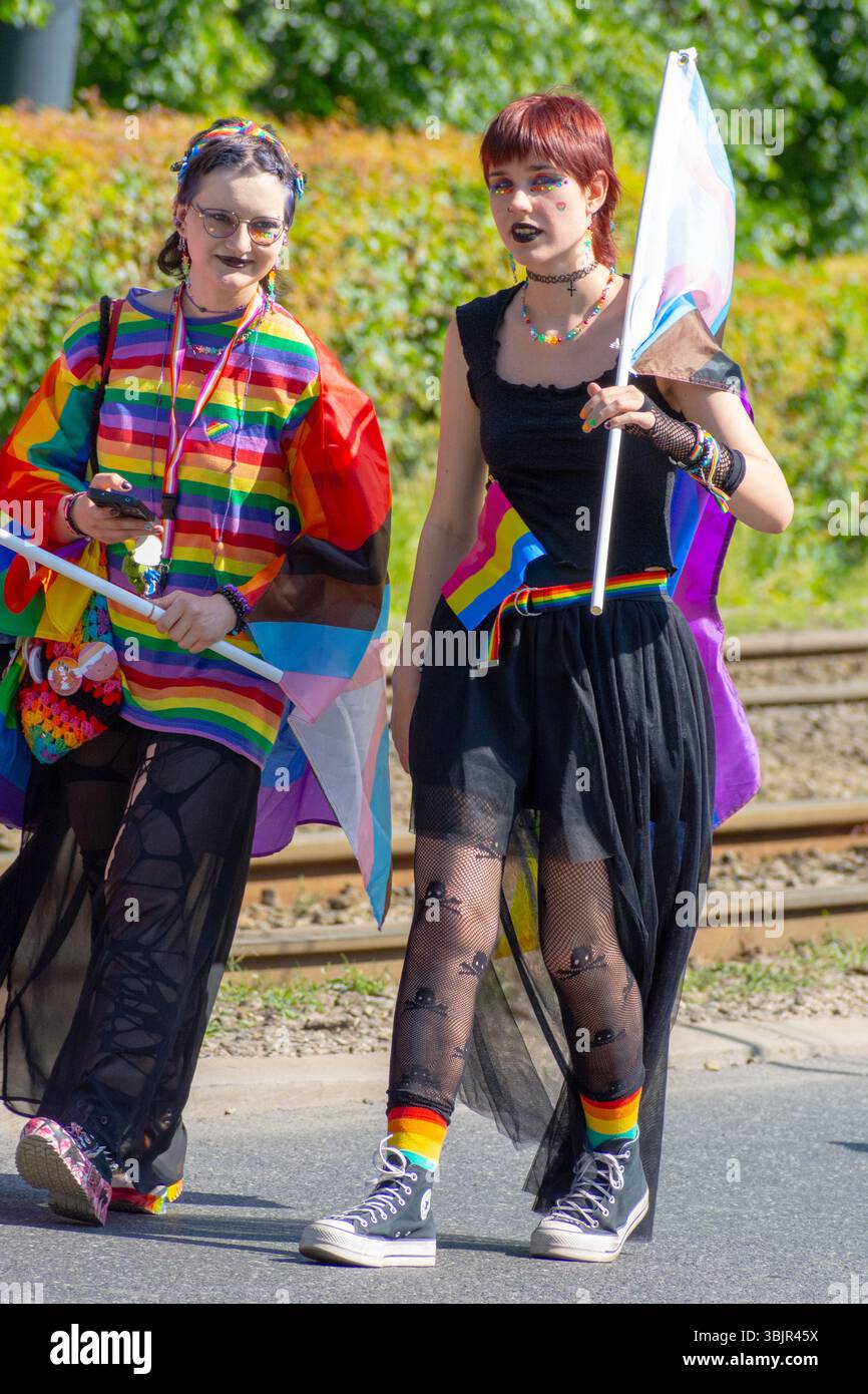 Zwei Teilnehmer in Regenbogenkleidung tragen Stolz-Fahnen bei der Warschauer Pride Parade in Warschau, Woiwodschaft Masowien, Polen, Juni 2025. Stockfoto