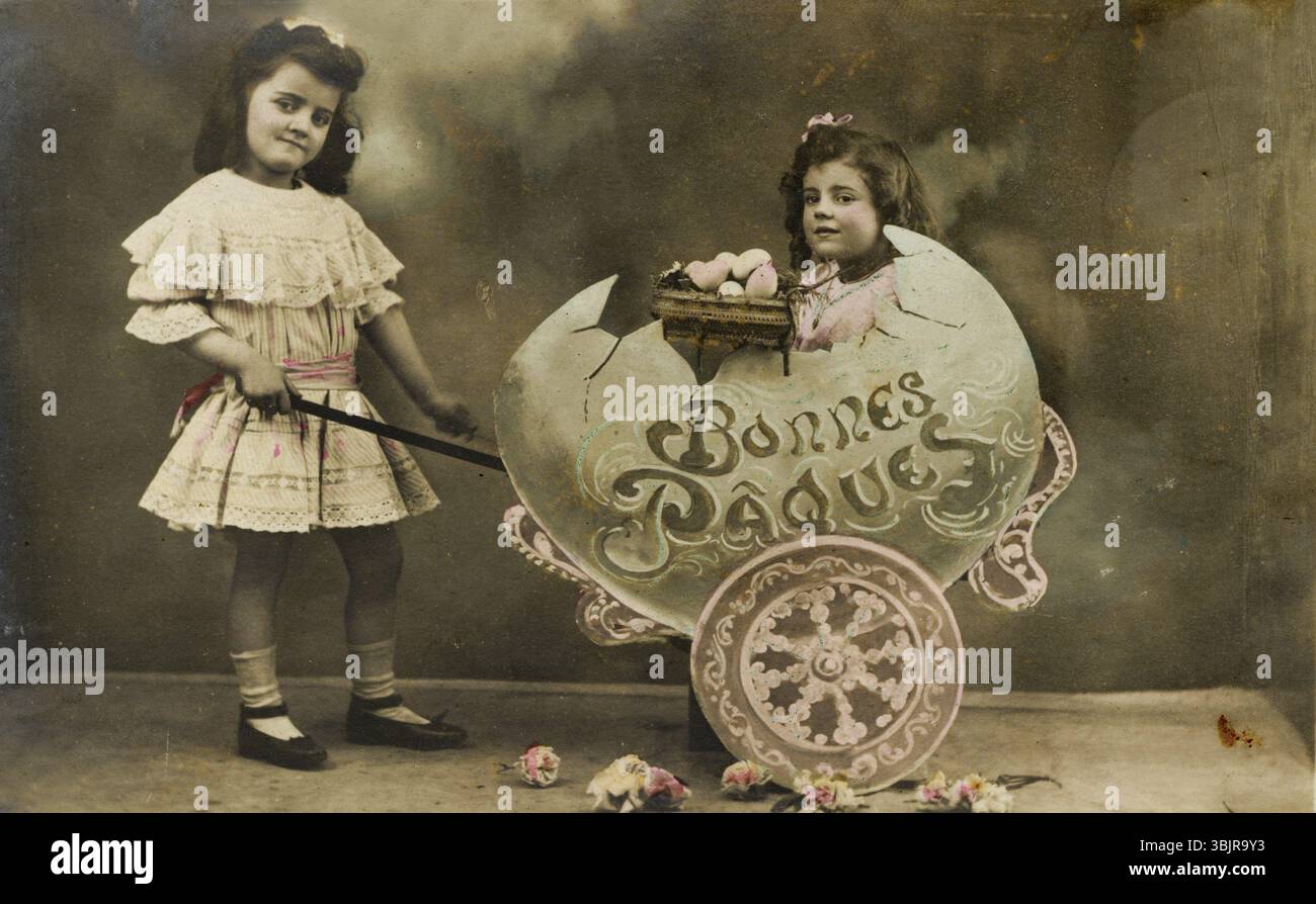 Kind, das in einem großen Ei sitzt, 1930er Jahre, zwei Mädchen in einem Vintage-Osterfoto mit Blumen und Dekoration, historisches Foto Stockfoto