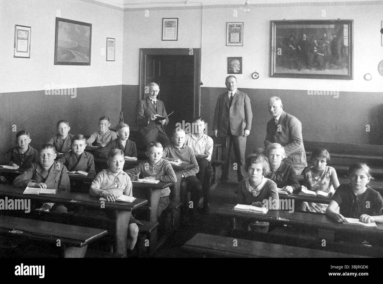 Schulklasse 3 Lehrer, ca. 1920, Schüler sitzen im Klassenzimmer, Lehrer stehend, klassische Einrichtung, historische Schulatmosphäre, historische Pho Stockfoto