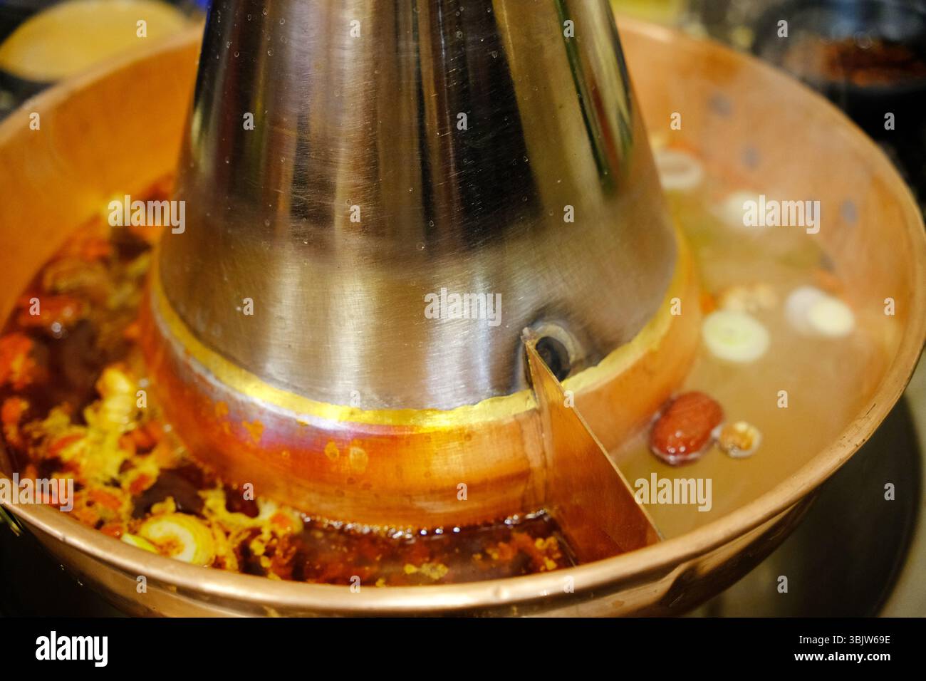 Nahaufnahme traditioneller chinesischer Kupfertopf mit dualer Bouillon. Stockfoto