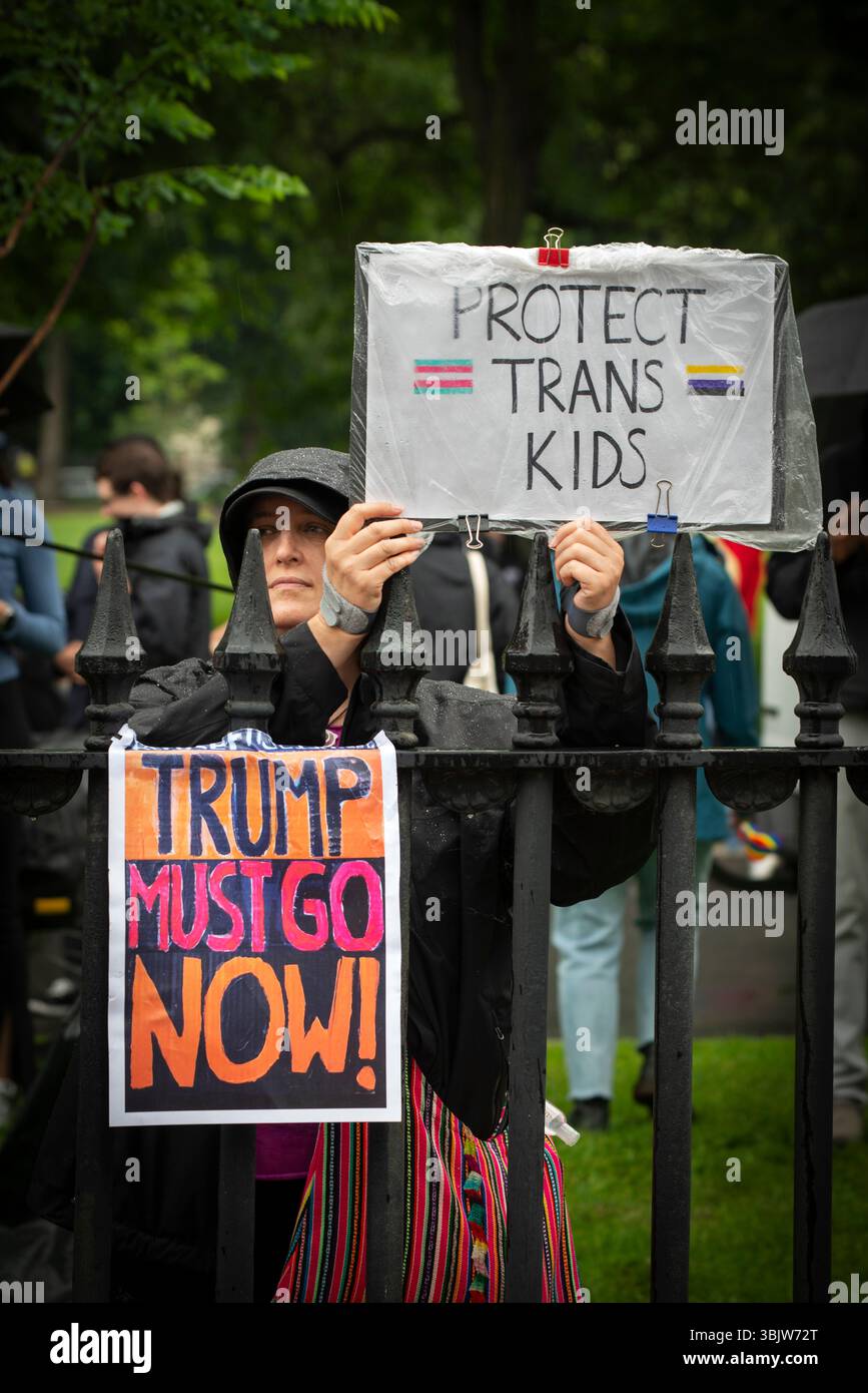 „No Kings“ und Boston Pride, Boston, MA, USA. 14. Juni 2025. Einer der Tausenden, die die Route entlang der Boston Parade säumten. Frau am Ende der Parade hält ein Schild über den Schutz von Transgender-Kindern. Stockfoto