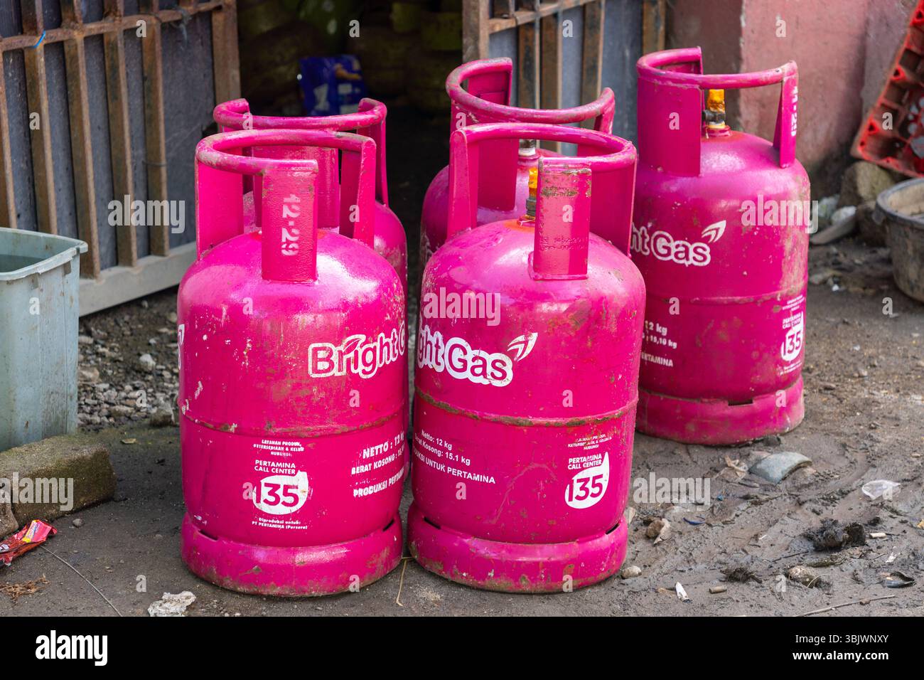 Gili, Lombok, Indonesien - 3. Januar 2025: Eine Reihe rosafarbener Gastanks sitzt auf dem Boden. Die Tanks sind mit dem Namen Bright Gas beschriftet Stockfoto