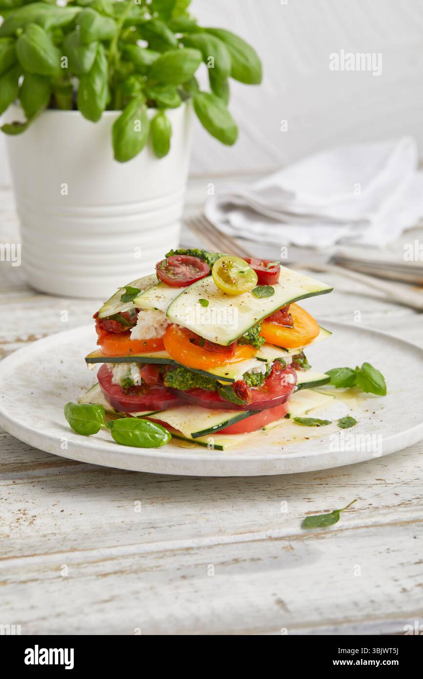 Rohe Zucchini und Lasagne aus Tomaten – ein frisches, ungekochtes Gericht auf Pflanzenbasis mit Kräutern und Gemüse, perfekt als gesundes veganes Mittagessen. Stockfoto